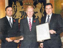 Receiving their Investor In People accreditation from Sir Reg Empey are Brendan Flynn and Brian Lewis from Federal Security Services