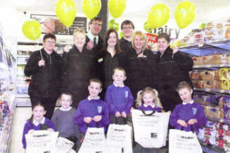 Staff at the new look Co-Op supermarket on Lisburn's Longstone Street with children from Tonagh Primary School. U54908-539cd