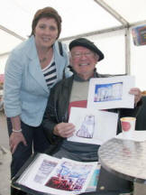 Local artist Graham Catney shows his work to Jenny Palmer (Lisburn City Council Economic Development Chairman) at the Farmers’ Market in Castle Gardens.