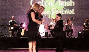 Braiden Lenaghan presenting a Lisburn City plaque to the festival organisers after the Eileen Depo McGuigan School of Irish Dancing from Lisburn took part in the first European Celtic Irish Dance Festival held recently in EuroDisney Paris.