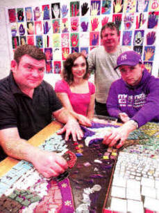 Sandra Robinson (seated centre) and Cohn McGookin (standing) assisting service users at Lagan Valley Hospital to create a new mosaic for the hospital building.